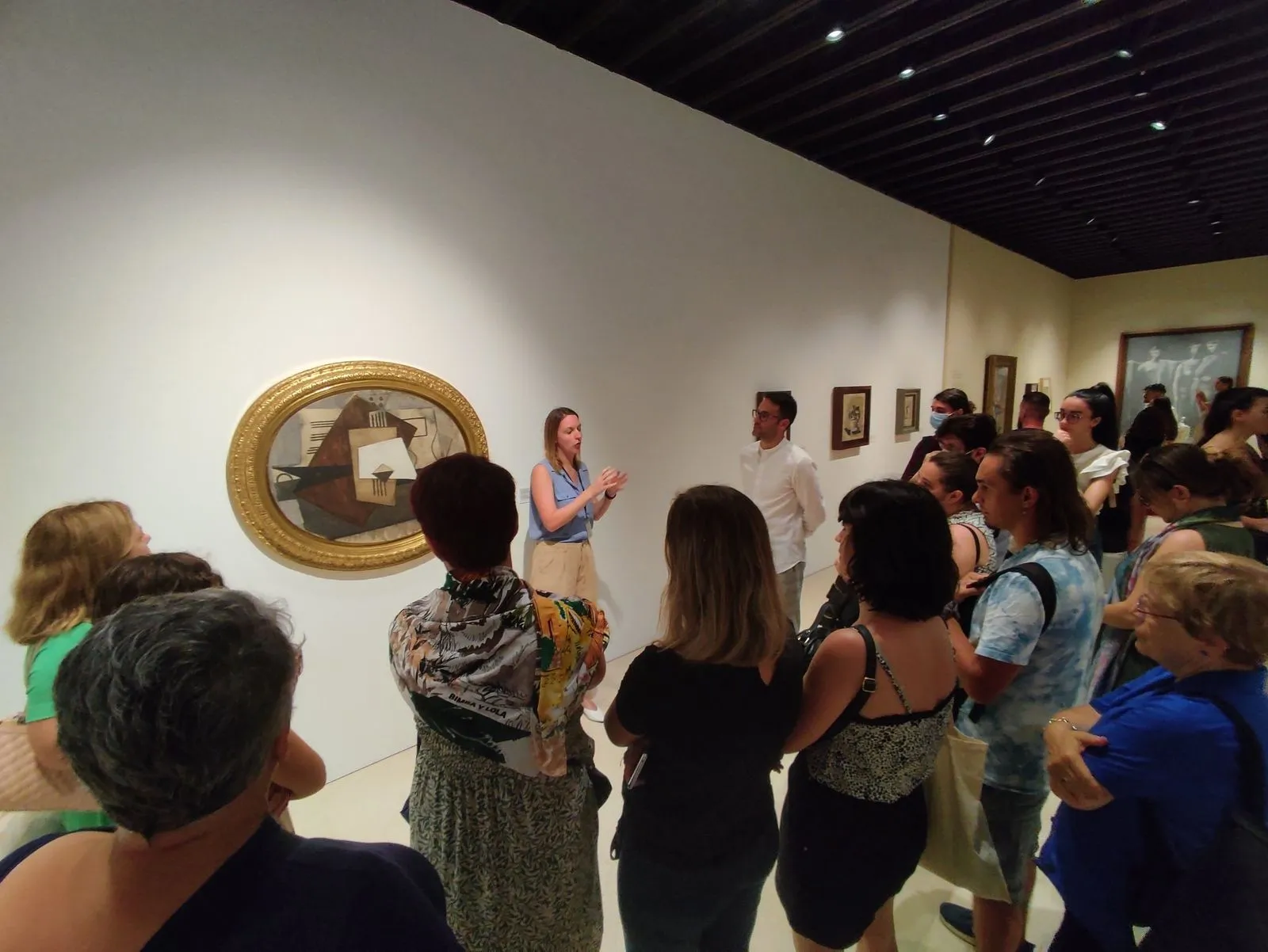 The group gathered around a Cubist still life in an oval gilt frame as Anaïs talks it through.